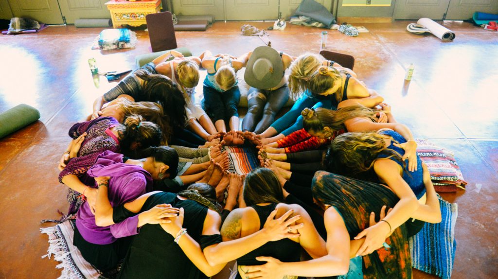 Group of people huddled in a circle on the floor