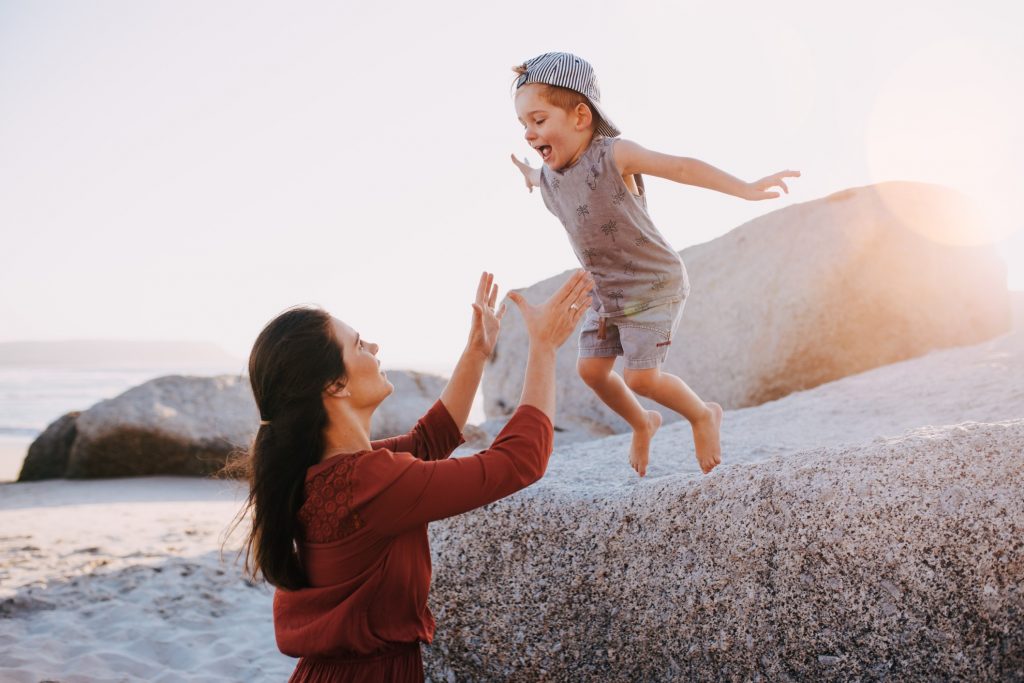 Happy mother playing with her son on a beach