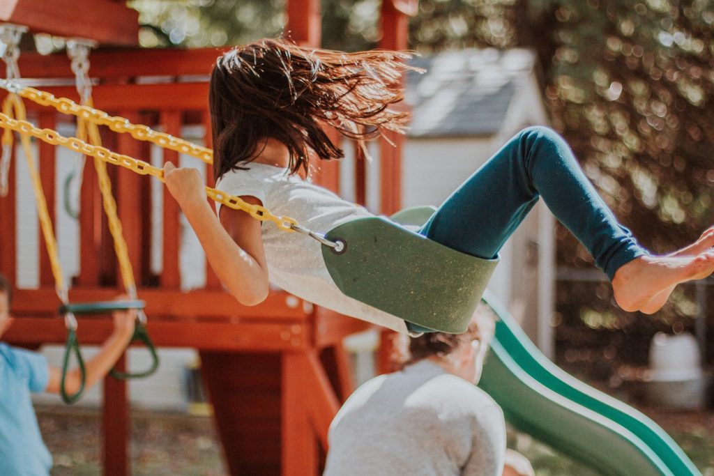 Young girl playing on a swing in a park